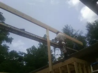 Carpenter setting a ridge beam over a new addition frame — Ice Dam Removal by Roofing Brothers in Port Chester