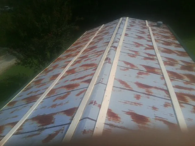Rusted metal roof panels with new wood purlins before replacement — Storm Damage Roof Repair in Port Chester by Roofing Brothers